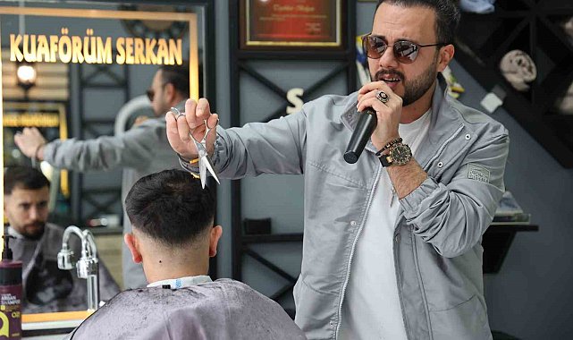 Bir elinde makas diğer elinde mikrofon